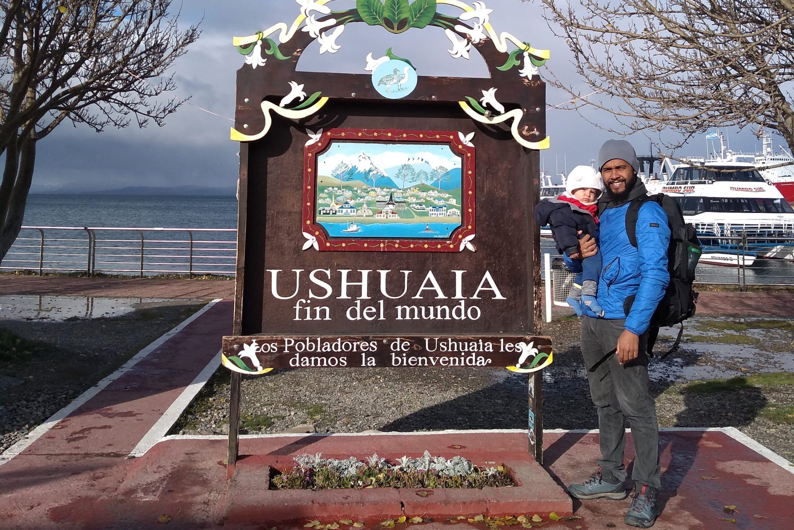 selfie de uma famlia: pai e filho na placa da cidade de Ushuaia
